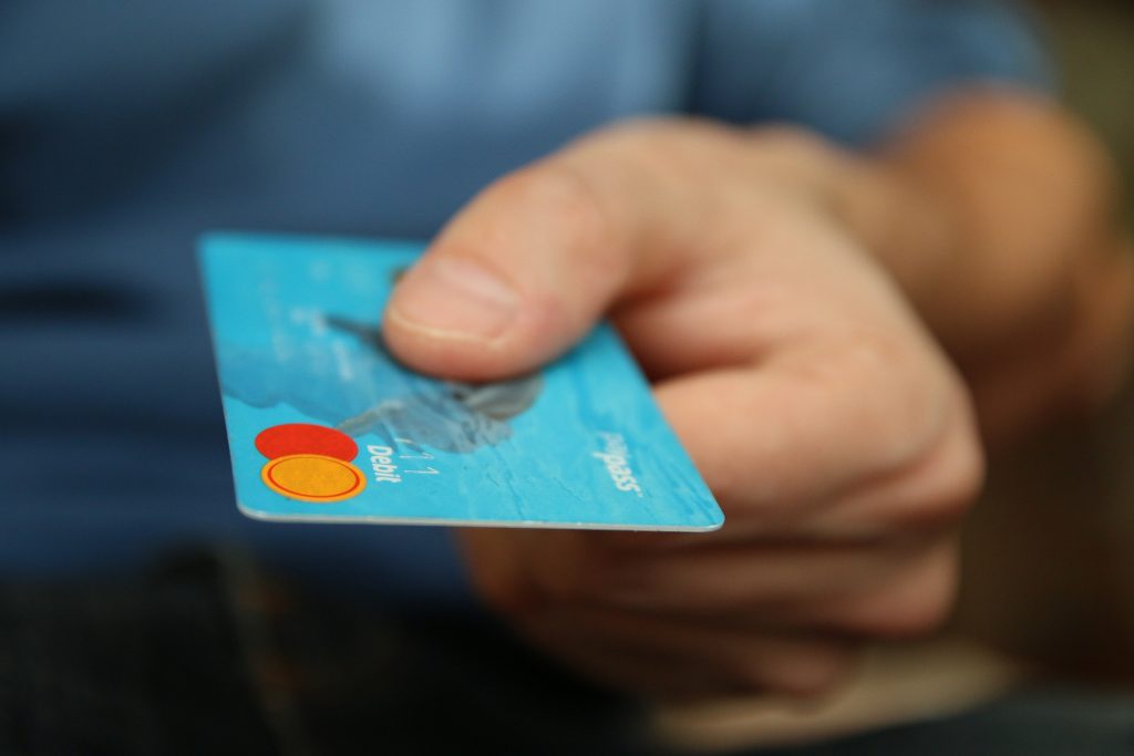 Image of a man holding a debit card